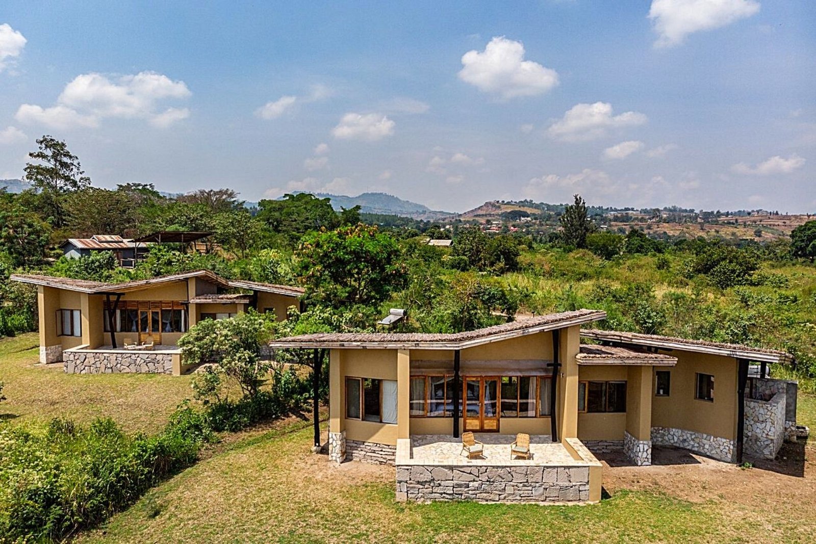 Kyambura Gorge Lodge sits on the edge of Kyambura Gorge overlooking the savannah of Queen Elizabeth National Park with the Rwenzori Mountains visible in the distance. The lodge was converted from a